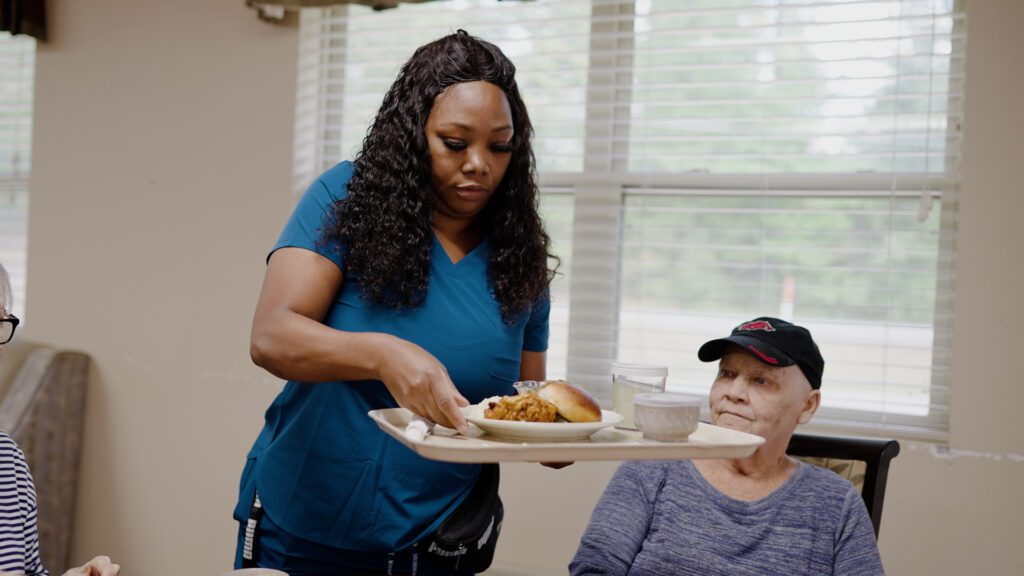 A nurse bringing food to a respite care patient at a skilled nursing facility