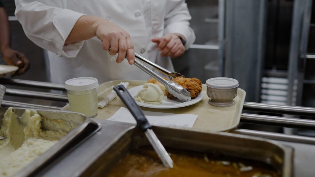A nutritionist making a plate for residents at a skilled nursing facility