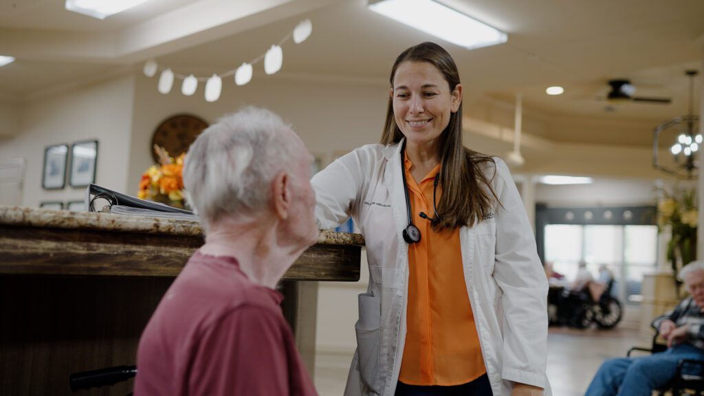 A nurse talking to a man in a skilled nursing facility