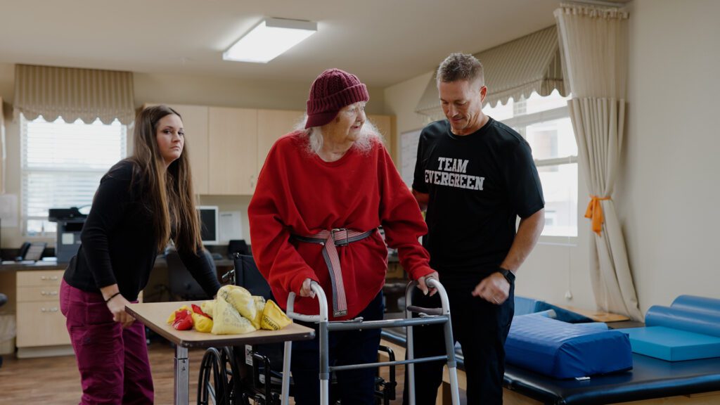 A woman and two nurses work in a physical therapy skilled nursing facility